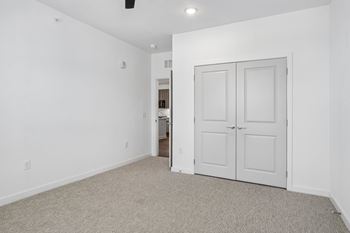 Empty bedroom with carpeting and double closet doors